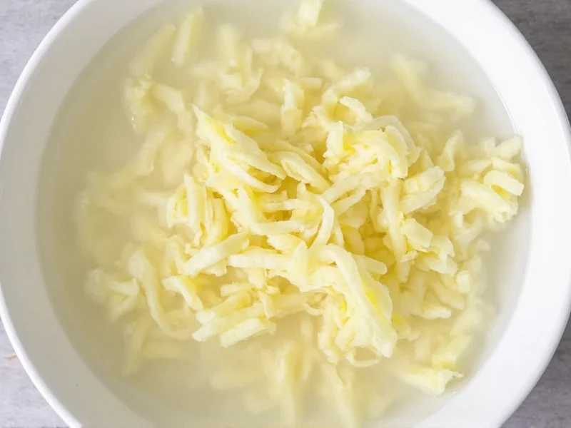 Shredded potatoes submerged in ice water bowl
