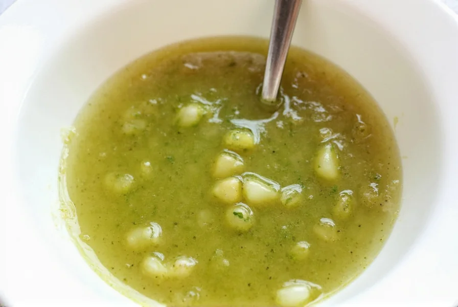 Freshly prepared ginger green onion sauce in a small ceramic bowl with chopsticks and ingredients arranged around it