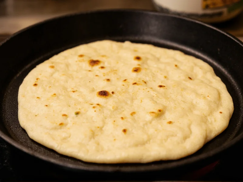 Close-up of tortilla puffing on hot cast iron skillet