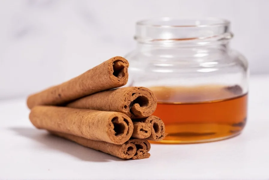 Glass jars with cinnamon sticks and other spices steeping in clear liquid for homemade bitters preparation