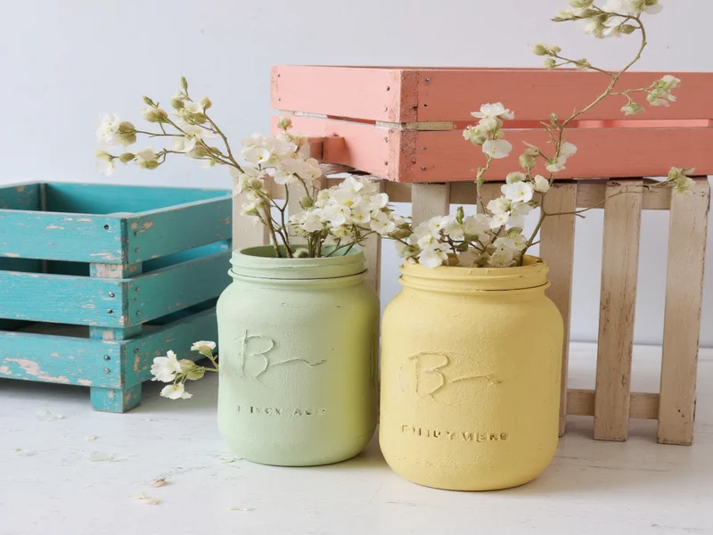 Finished craft paint projects on wooden crates and mason jars