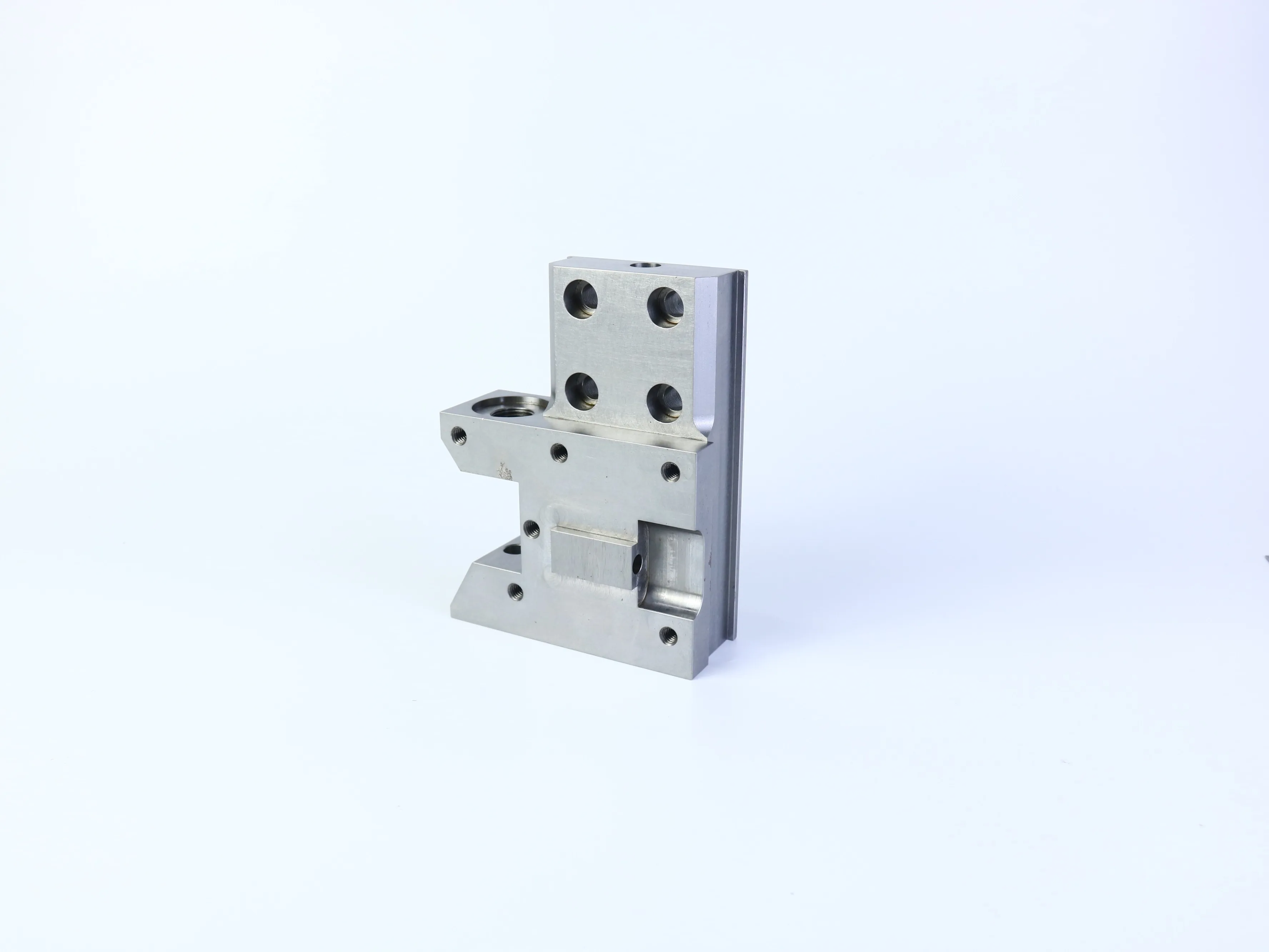 CNC milled mounting bracket with multiple holes, pockets, and perpendicular mounting faces