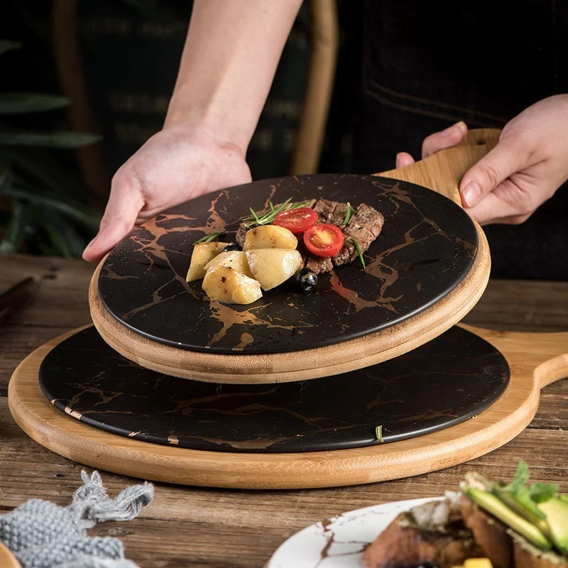 

Hot sale marble porcelain steak plate Western food dish home black ceramic round pizza plate wooden tray with handle