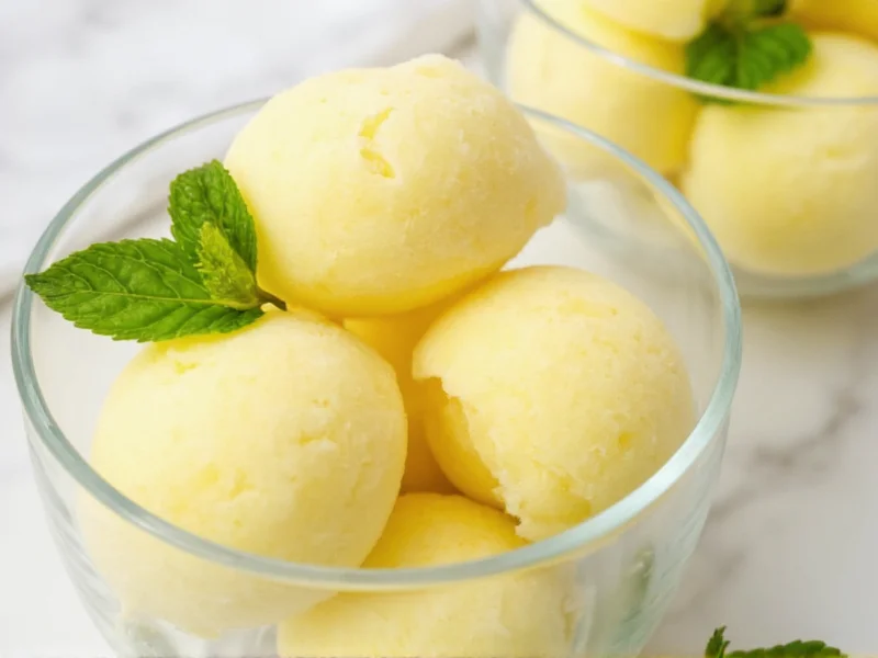 Homemade lemon sorbet in glass bowl with mint garnish