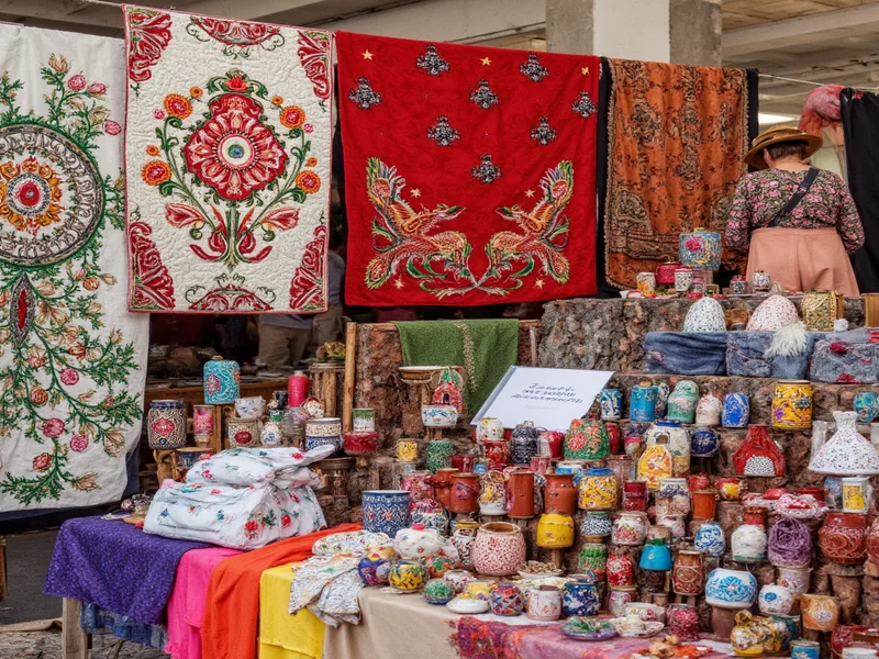 Diverse artisans displaying hand-embroidered textiles and ceramics at Renegade