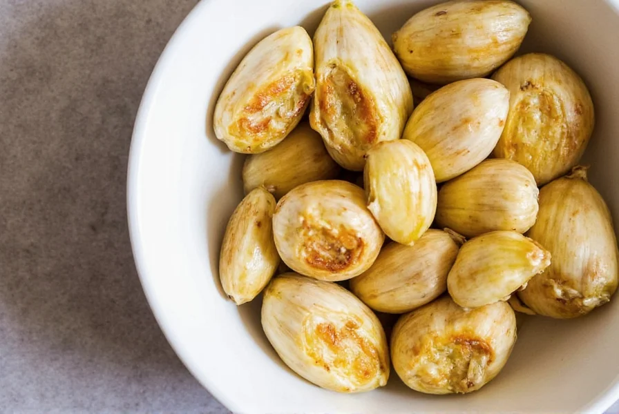Roasted garlic cloves being squeezed from skins