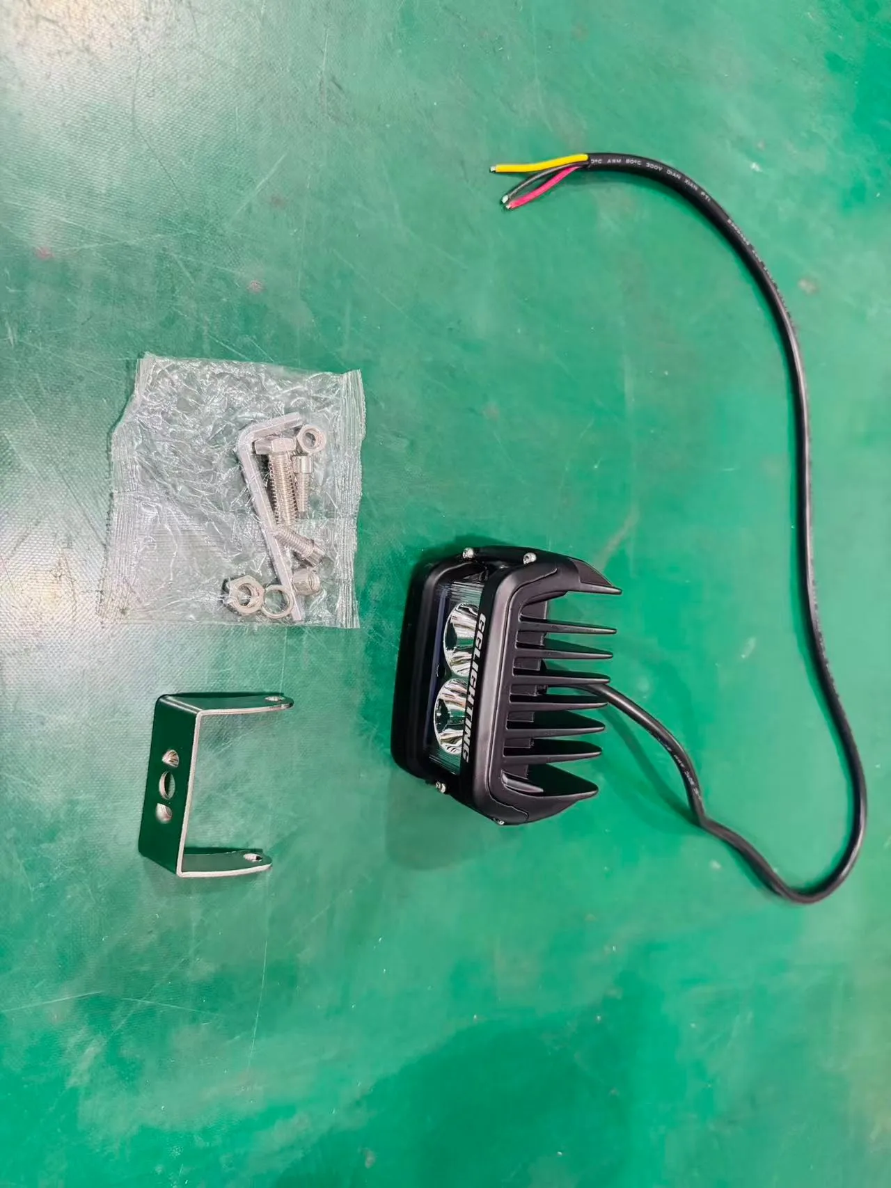 Motorcycle auxiliary light kit with mounting bracket, hardware bag and 12V wiring