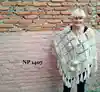 Knitted white poncho with big pom poms and tassels. 100% wool and made in Nepal.