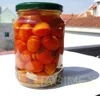 Pickled marinated tomato in glass jar - cherry tomato and medium tomato