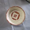 Brown round bamboo basket from vietnam with same color flower detail